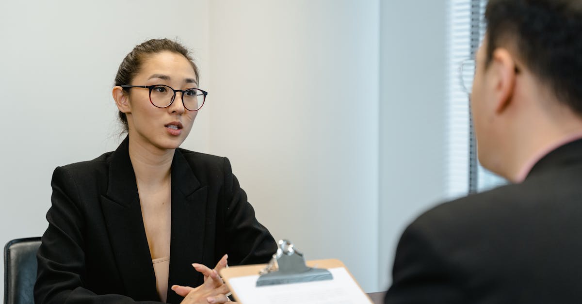 A focused interview scene in an office environment with business attire and a clipboard.